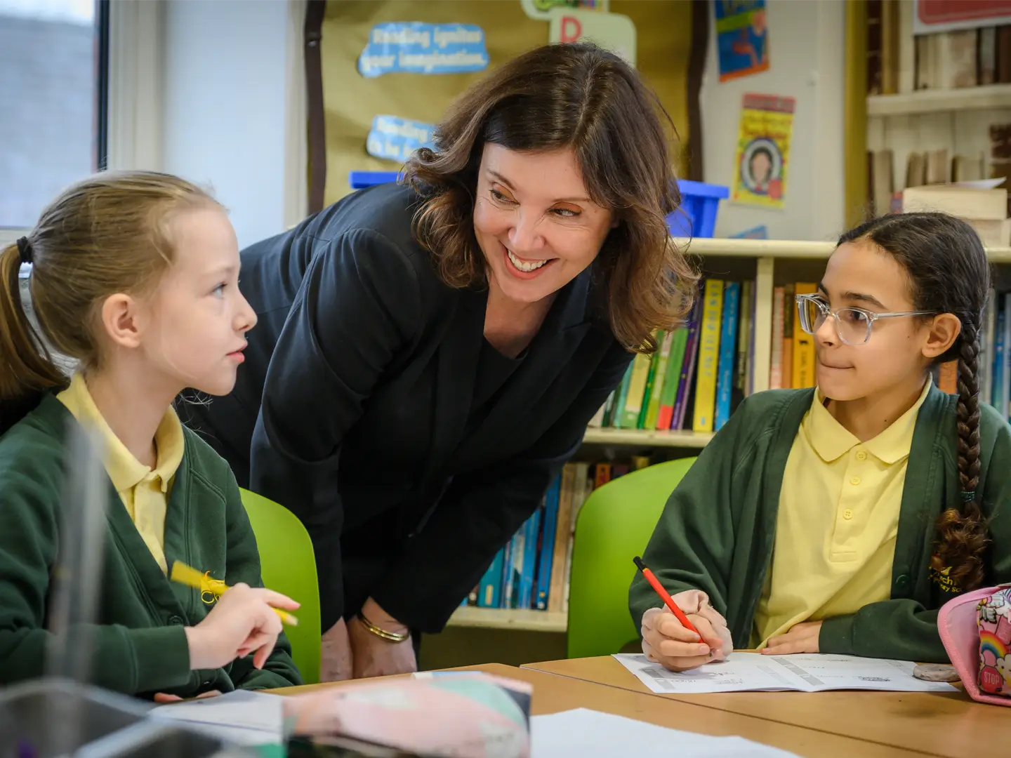 Dame Rachel de Souza talking to two school girls